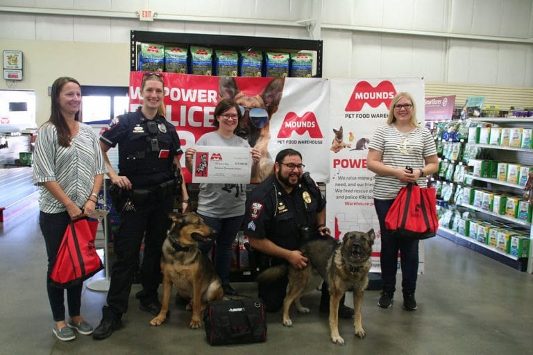 police and mounds employees with dogs and donation check